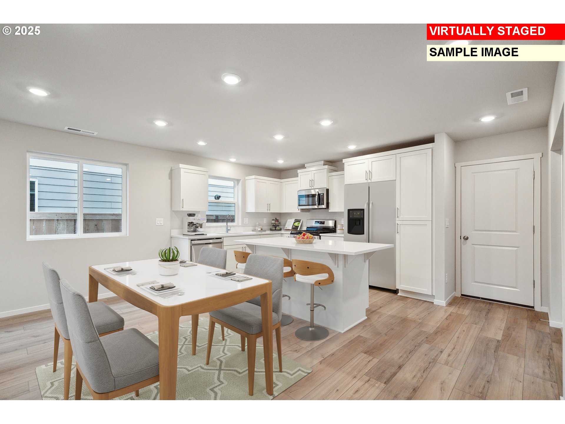 714 Merriott Lane Woodburn, OR 97071 - Photo 4 of 26 a kitchen with stainless steel appliances a white table chairs and a refrigerator