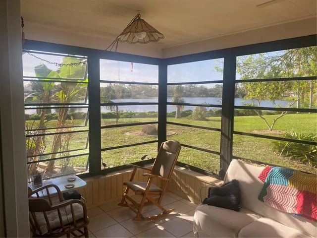 a view of a living room filled with furniture and floor to ceiling windows
