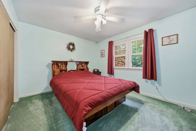 a bed sitting in a bedroom next to a window