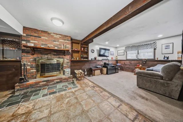 a living room with furniture a fireplace and a flat screen tv