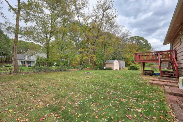 a front view of a house with a yard and tree s