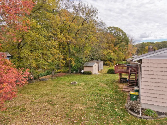 a view of a big house with a big yard and large tree