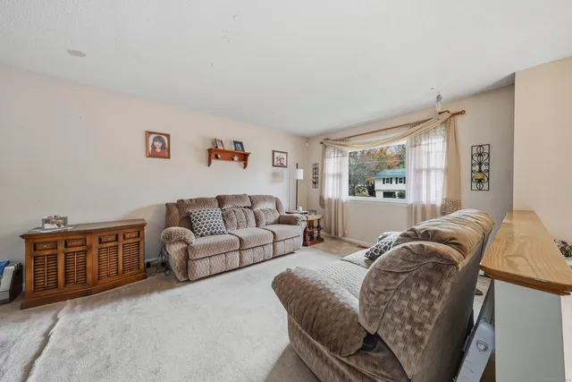 a living room with furniture a bed and a window