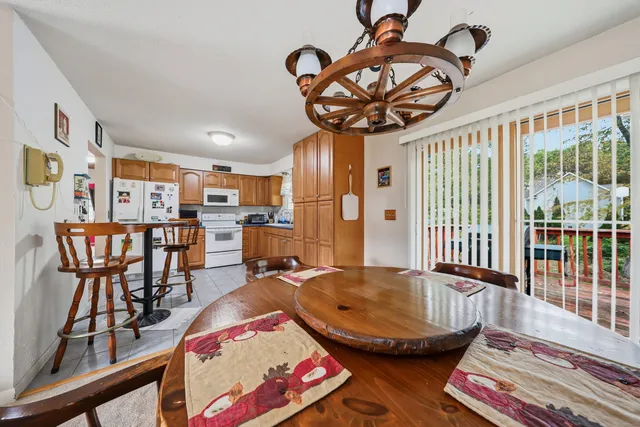 a view of a dining room with furniture a chandelier and wooden floor