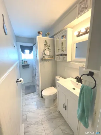 a bathroom with a toilet sink and mirror