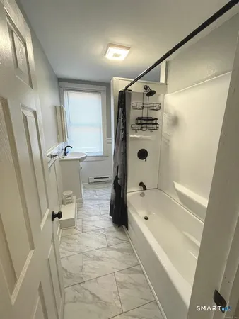a bathroom with a tub a sink and a shower