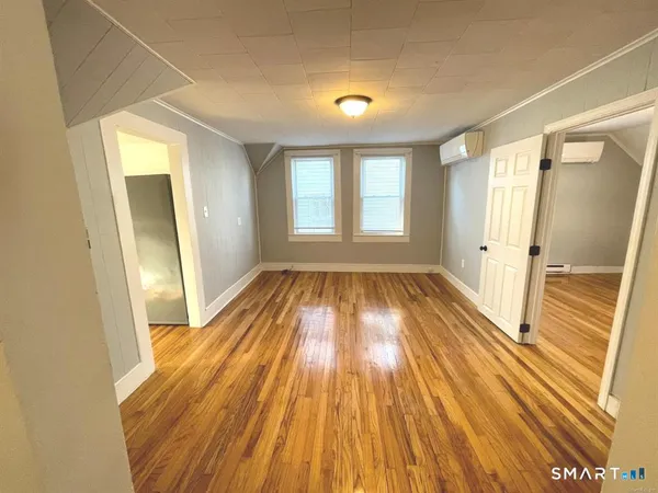 a view of a room with wooden floor and window