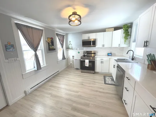 a kitchen with a sink cabinets stainless steel appliances and a window