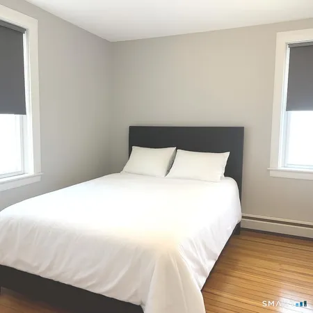 a large bed sitting in a bedroom next to a window