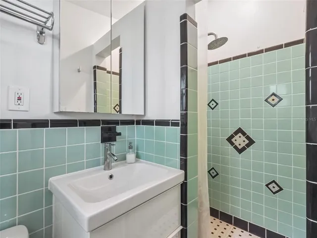 a bathroom with a sink a shower and a mirror
