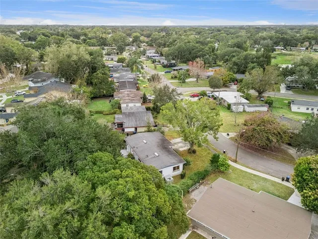 an aerial view of residential houses with outdoor space and trees