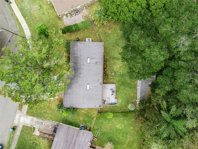 an aerial view of a house with a yard and trees