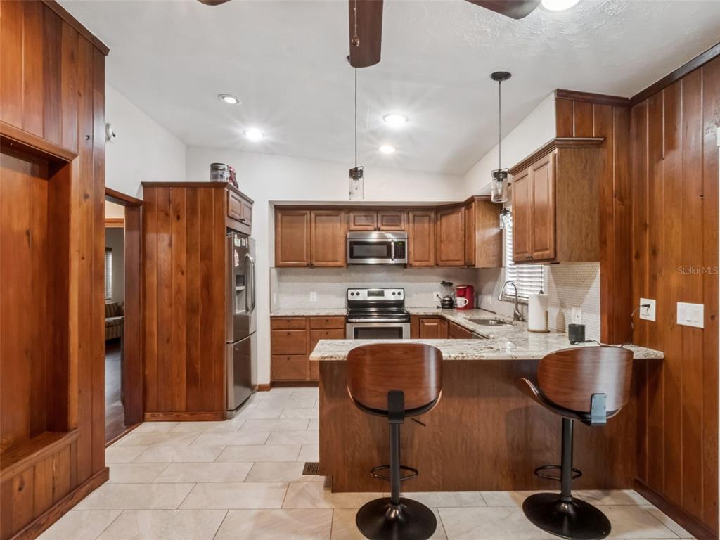 2819 Rogan Road Orlando, FL 32812 - Photo 4 of 28 a kitchen with stainless steel appliances granite countertop a refrigerator and a stove top oven