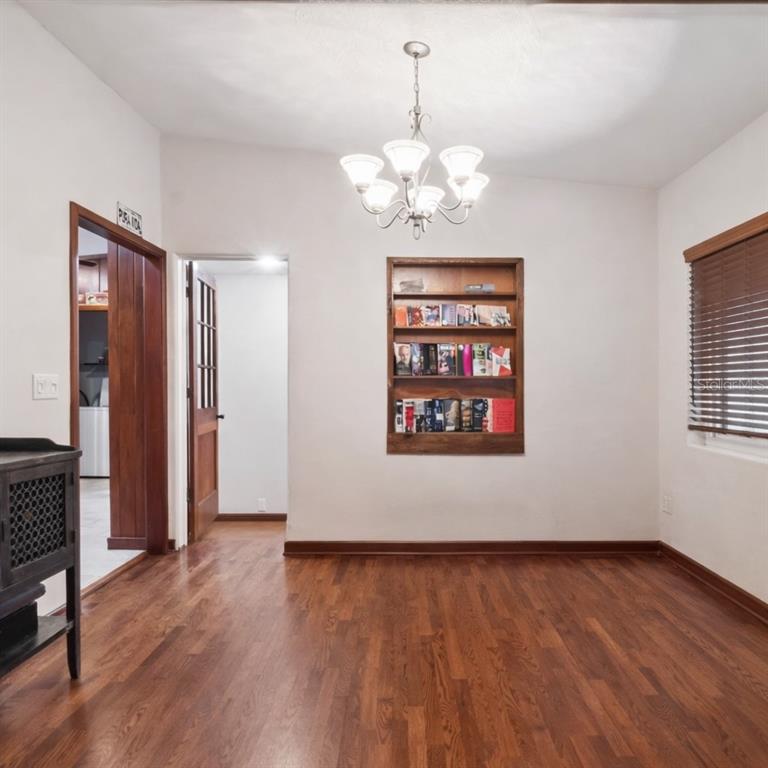 2819 Rogan Road Orlando, FL 32812 - Photo 9 of 28 a view of an empty room with wooden floor and a window