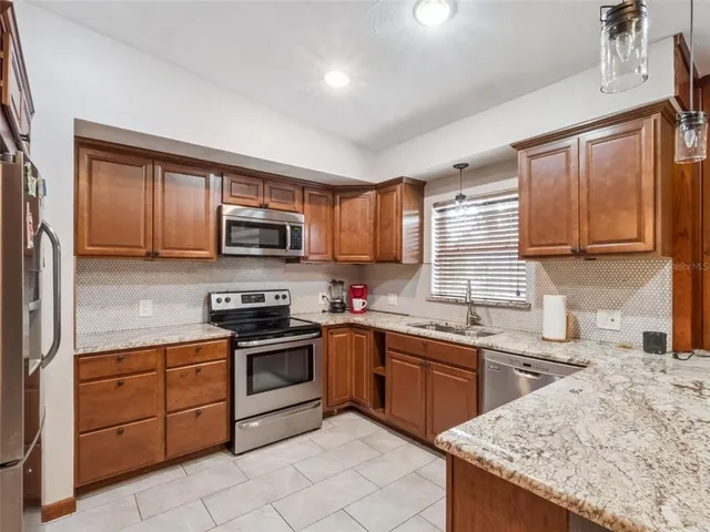 a kitchen with stainless steel appliances granite countertop a sink stove microwave and cabinets