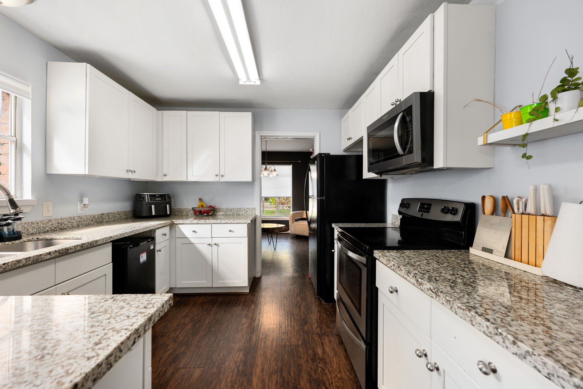 6019 Cartagena Street Houston, TX 77035 - Photo 15 of 29 a kitchen with stainless steel appliances granite countertop a stove a sink dishwasher and a microwave oven with wooden floor