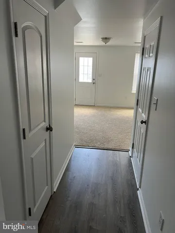 an empty room with wooden floor and staircase