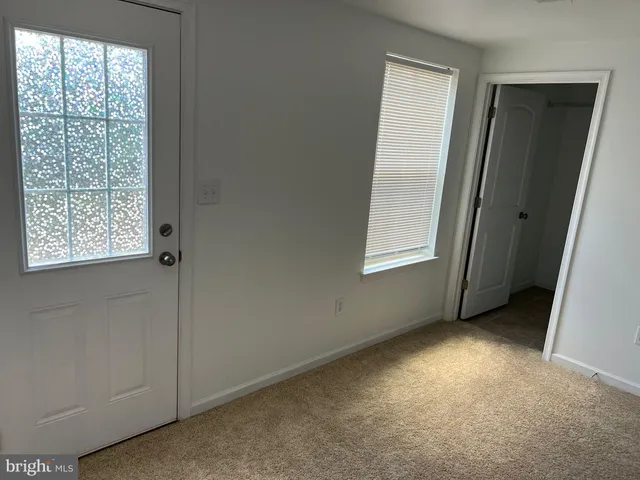 an empty room with windows and closet