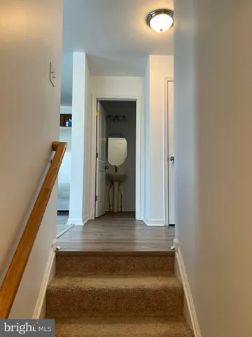 a view of a hallway with wooden floor and staircase