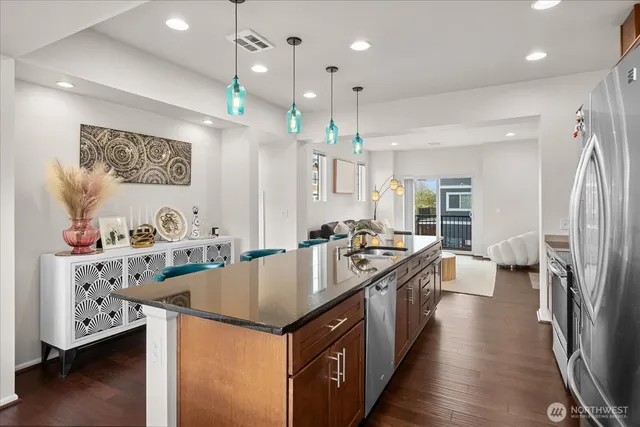 a kitchen with stainless steel appliances granite countertop a sink a stove and a refrigerator