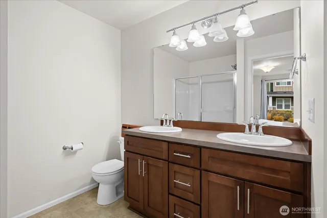 a bathroom with a granite countertop sink a toilet and a mirror