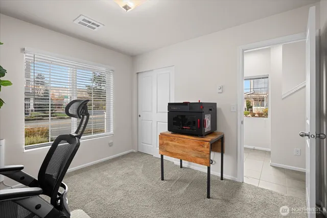 a view of a workspace with furniture and a window