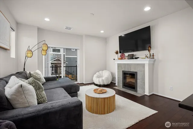 a living room with furniture a flat screen tv and a fireplace