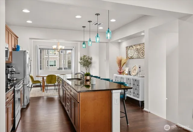 a kitchen with stainless steel appliances granite countertop a refrigerator a stove and a sink