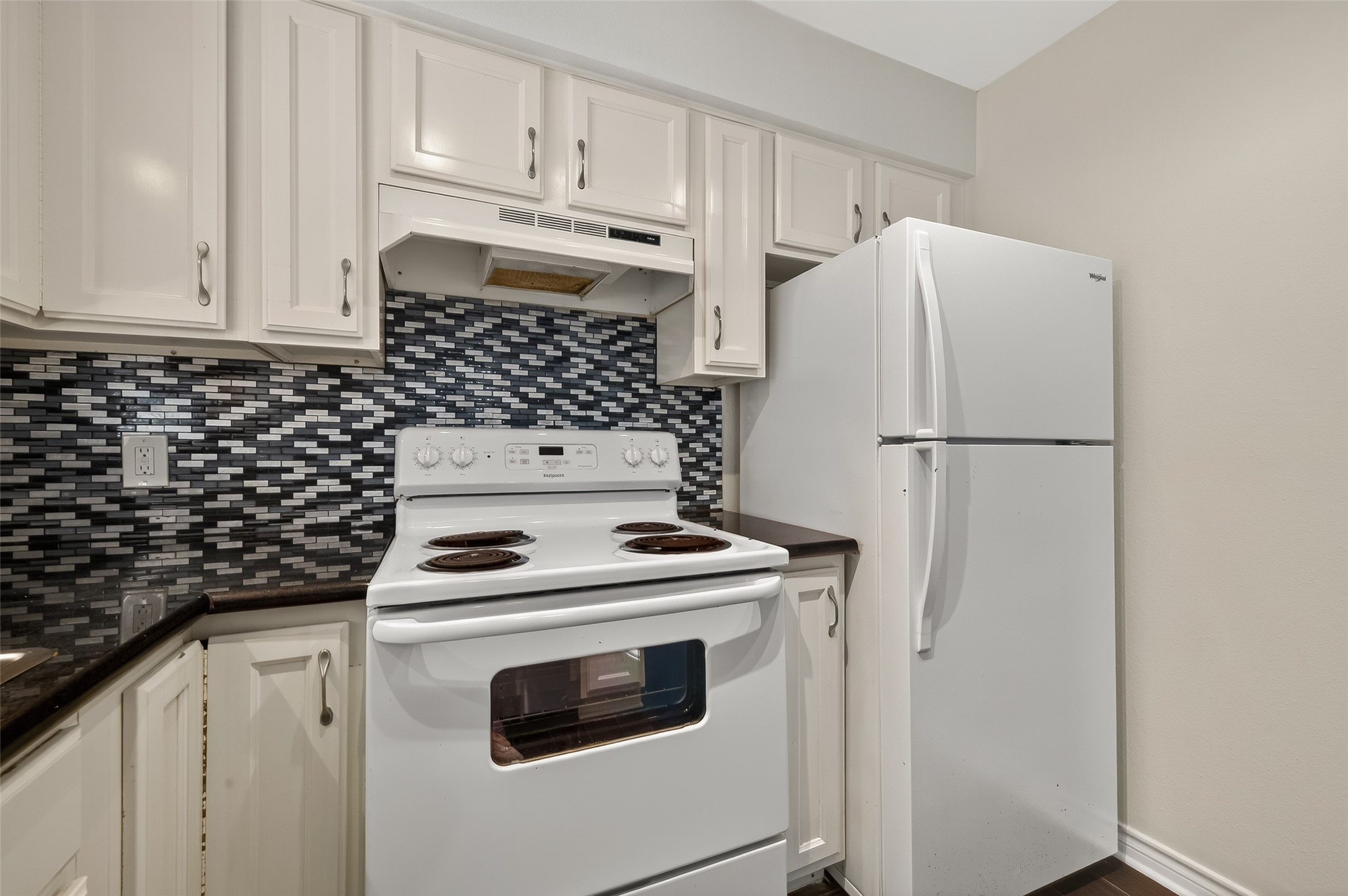 2020 Huldy Street, Unit 2 Houston, TX 77019 - Photo 20 of 34 a kitchen with refrigerator a stove and white cabinets