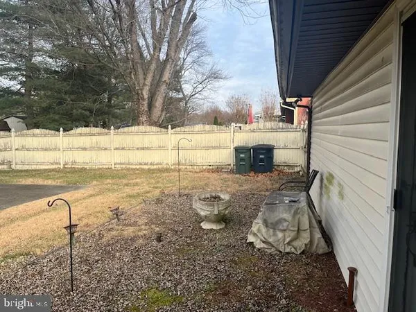 a view of a yard with wooden fence