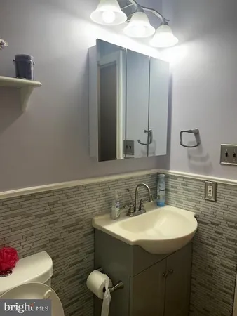 a bathroom with a sink a toilet and mirror