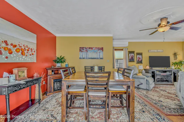 a living room with furniture a flat screen tv and paintings on the wall