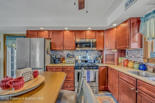 a kitchen with stainless steel appliances granite countertop a refrigerator a sink dishwasher stove top oven and cabinets