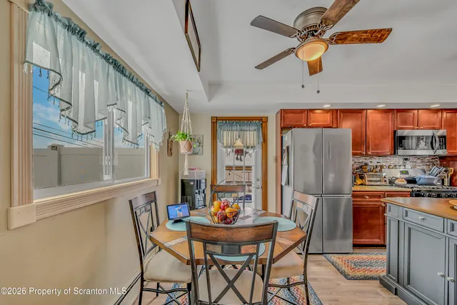 a dining room with stainless steel appliances kitchen island granite countertop furniture and a refrigerator