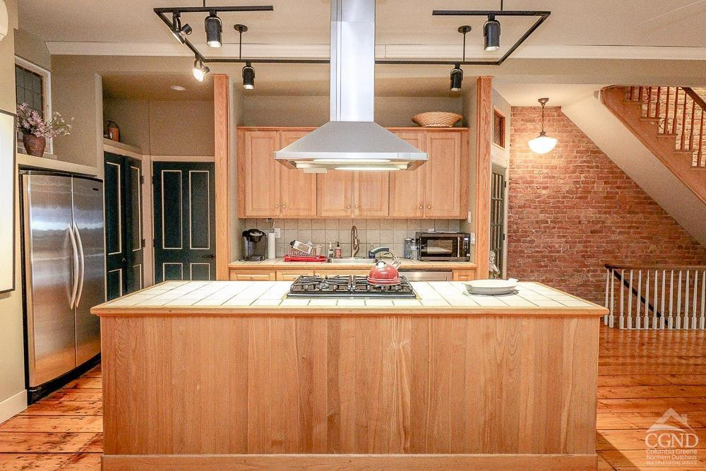 258 Warren Street Hudson, NY 12534 - Photo 7 of 31 a large kitchen with stainless steel appliances kitchen island granite countertop a refrigerator a oven and a sink with wooden floor