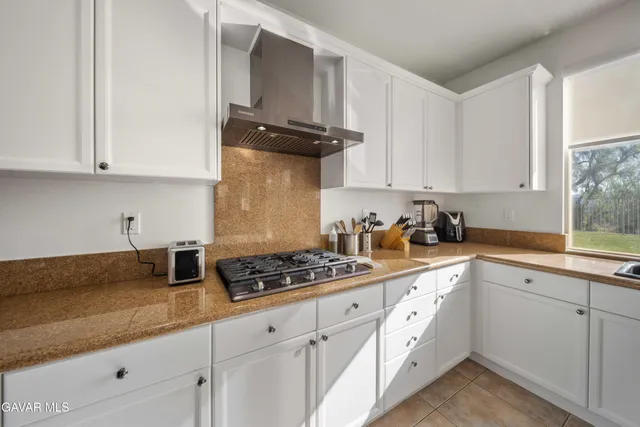 a kitchen with granite countertop white cabinets and white appliances