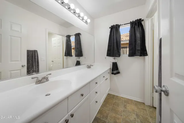 a bathroom with a double vanity sink and mirror