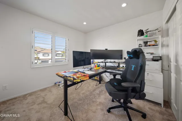 a view of a workspace with furniture and a window