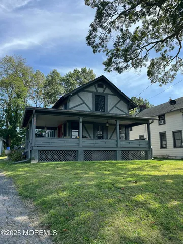 a view of a house with a big yard and large tree