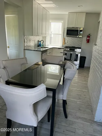 a kitchen with a table chairs microwave and cabinets