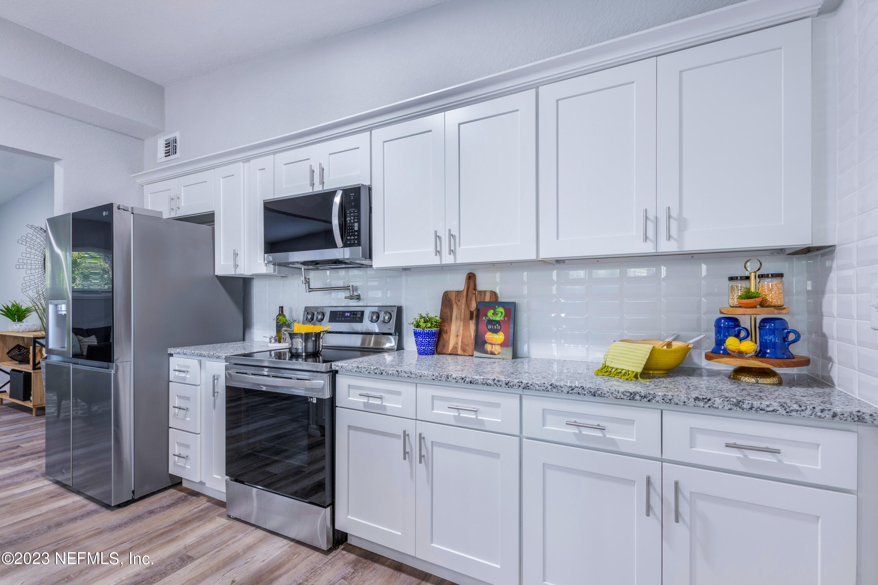 1226 Morgana Road Jacksonville, FL 32211 - Photo 11 of 38 a kitchen with white cabinets and appliances