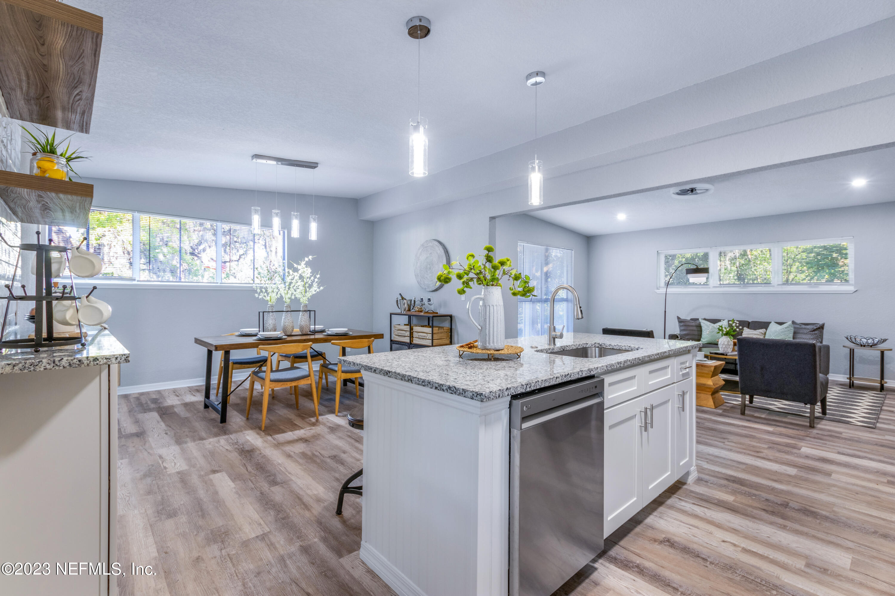 1226 Morgana Road Jacksonville, FL 32211 - Photo 13 of 38 a kitchen with stainless steel appliances granite countertop a stove a sink dishwasher and a dining table with wooden floor