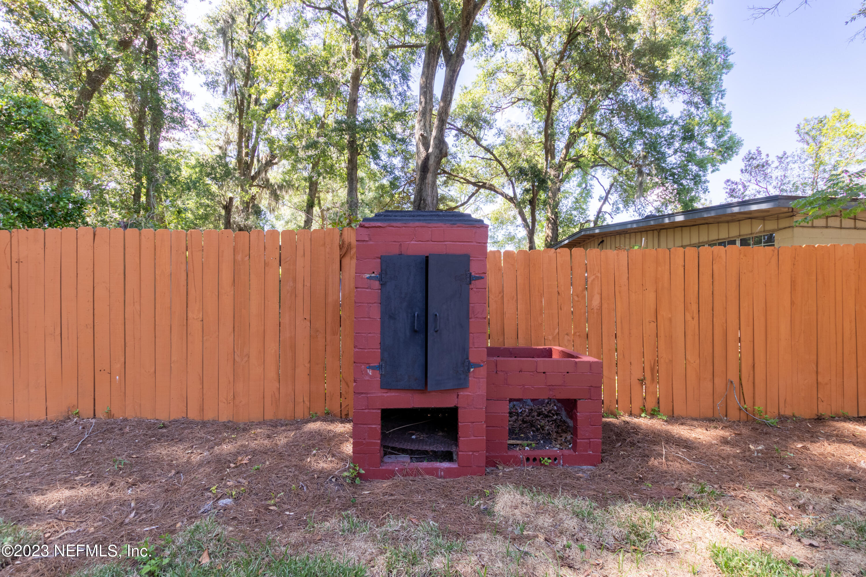 1226 Morgana Road Jacksonville, FL 32211 - Photo 38 of 38 a view of a small yard with wooden fence and a large tree