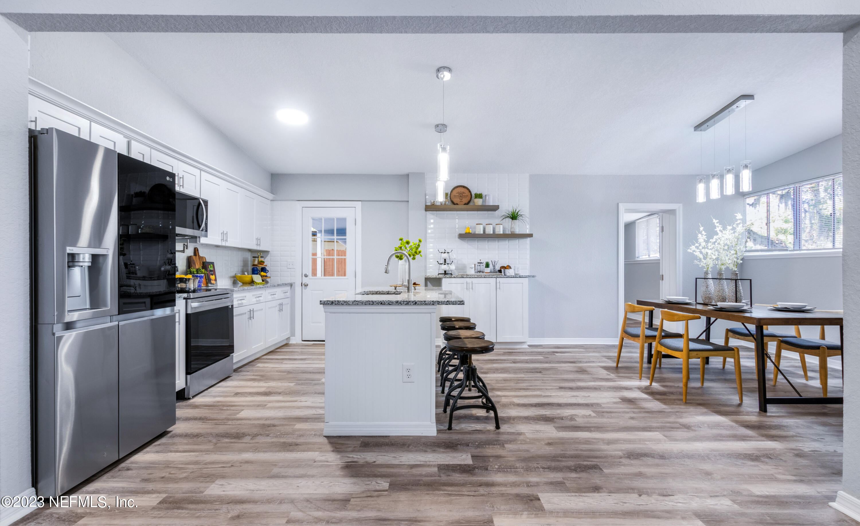 1226 Morgana Road Jacksonville, FL 32211 - Photo 10 of 38 a kitchen with stainless steel appliances kitchen island granite countertop a table chairs microwave and sink