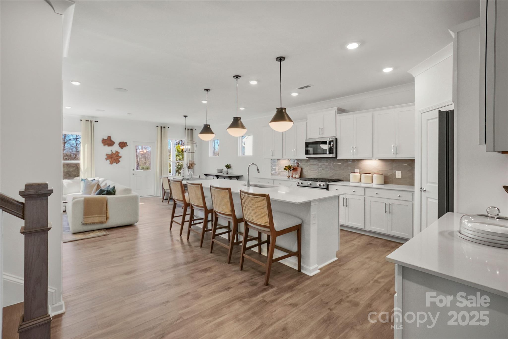 2213 Dickson Court, Unit 52 Monroe, NC 28110 - Photo 11 of 48 a kitchen with kitchen island granite countertop a sink cabinets and wooden floor
