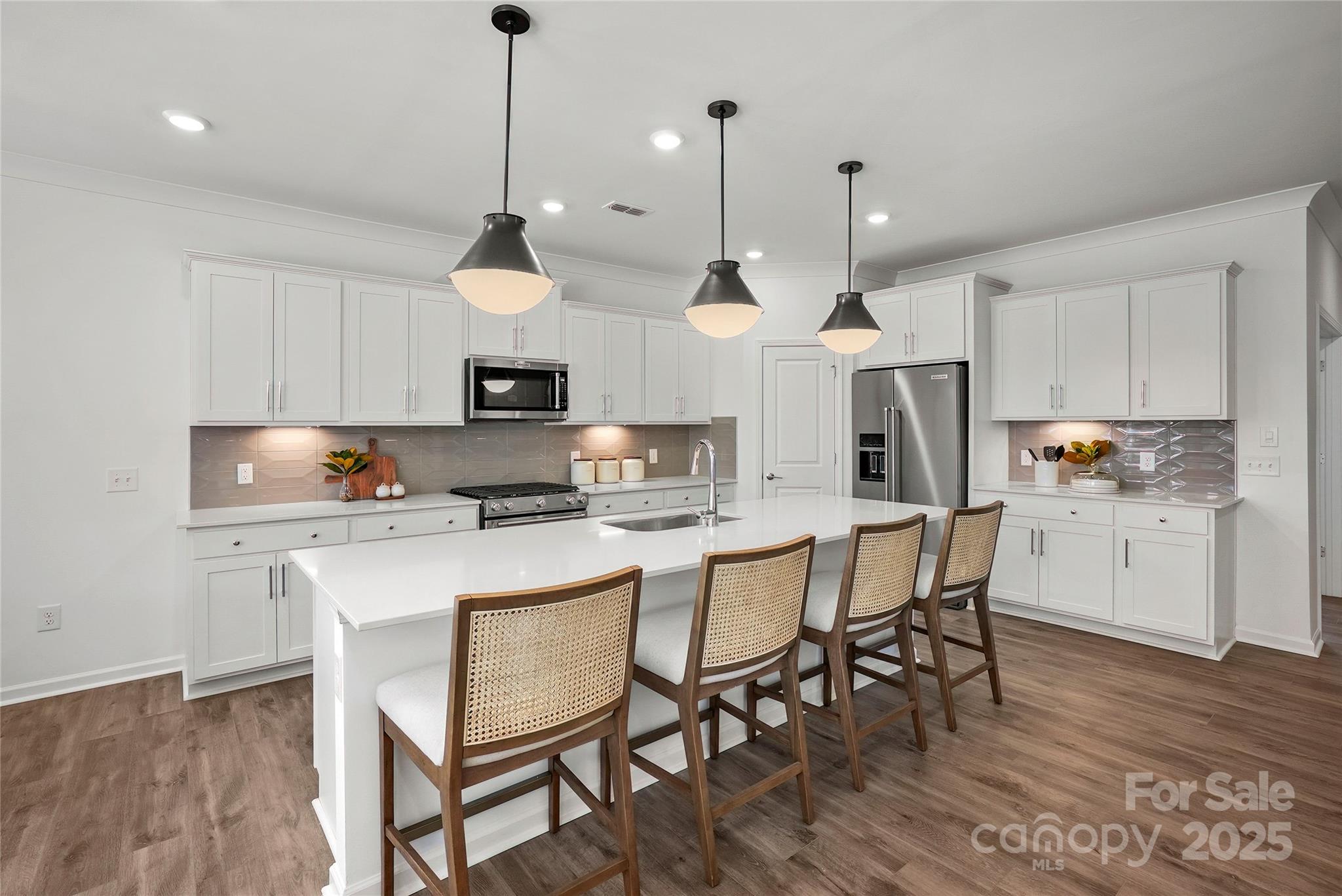 2213 Dickson Court, Unit 52 Monroe, NC 28110 - Photo 12 of 48 a kitchen with stainless steel appliances a dining table chairs a sink and a refrigerator
