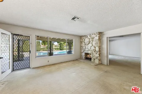 a view of a livingroom with an empty space and a window