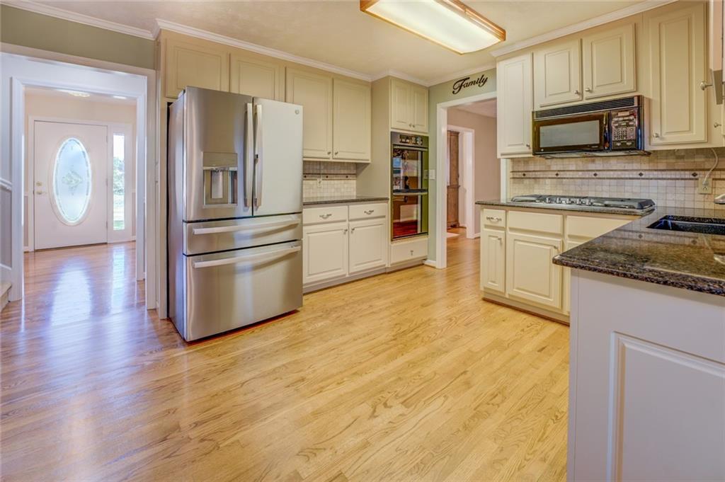 740 Smyrna Road Southwest Conyers, GA 30094 - Photo 12 of 50 a kitchen with granite countertop a refrigerator stove and microwave