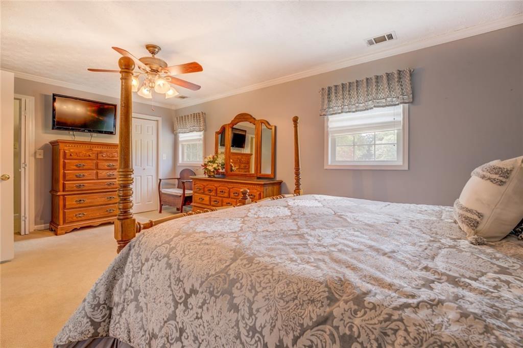740 Smyrna Road Southwest Conyers, GA 30094 - Photo 25 of 50 a bedroom with a bed a dresser and flat screen tv