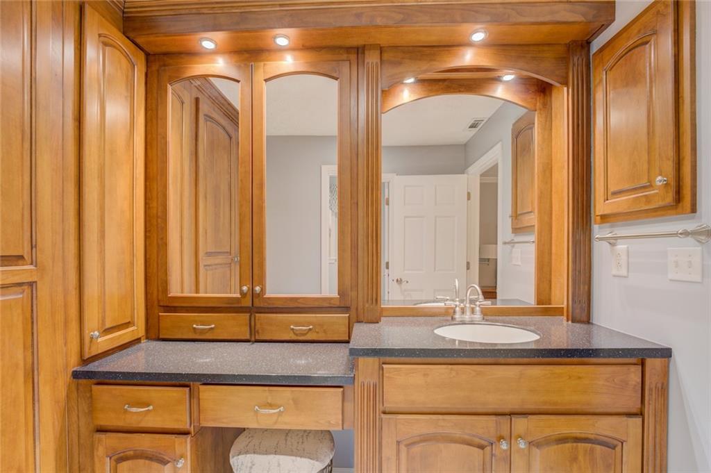 740 Smyrna Road Southwest Conyers, GA 30094 - Photo 28 of 50 a bathroom with a granite countertop sink and a mirror